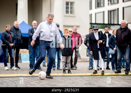 Oldenburg, Deutschland. 17. Mai 2023. Jürgen Krogmann (SPD), Oberbürgermeister von Oldenburg, schießt mit einem Fußball auf dem Schlossplatz auf eine Tormauer. Das vorläufige Programm des Erlebnis-Turnfestes in Oldenburg hat mit Demonstrationen im Stadtzentrum begonnen. Die offizielle Eröffnung der größten Sportveranstaltung in Norddeutschland mit rund 10.000 Teilnehmern findet am Abend statt. Kredit: Hauke-Christian Dittrich/dpa/Alamy Live News Stockfoto