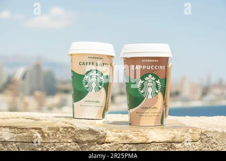 Starbucks Kaffeetasse im Freien. Starbucks Cappuccino Chiled Coffee und Caffe Latte Chilled Coffee to Go Coffee Tasse Kaffee mit Benidorm City und Mittelmeer Stockfoto