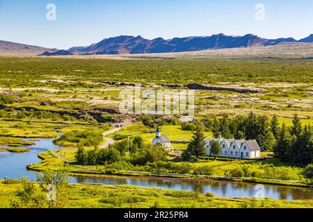 Blick über den Nationalpark Thingvellir mit der Kirche Thingvellir in Island und sonnigem Himmel Stockfoto