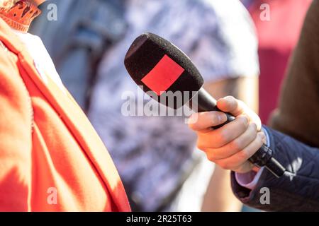 Reporter, der das Mikrofon hält, macht ein Medieninterview. Straßeninterview oder Vox popoli. Stockfoto