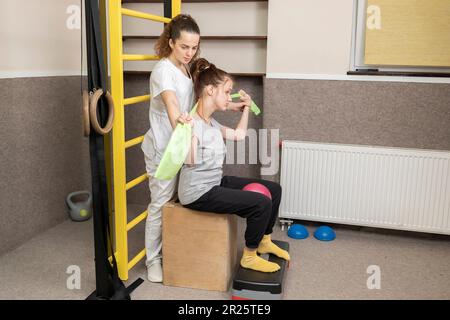 Behindertes Kind Mit Arzt Macht Körperliche Übungen Im Rehabilitationsraum. Kind Mit Besonderen Bedürfnissen. Rehabilitation. Zerebralparese. Motorische Störung Stockfoto