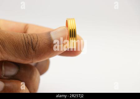 Der goldene Ring in der Hand. Wunderschöner Ehering aus Gold Stockfoto