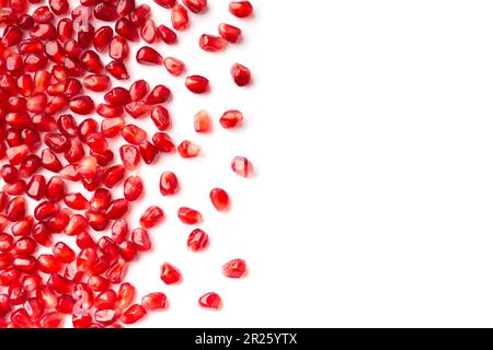 Rote Körner eines reifen Granatapfel auf weißem Hintergrund, Draufsicht mit Platzierung für Text. Granatapfelkörner auf isolierter Planlage. Hintergrund des Granatapfel Stockfoto