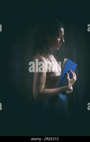 Frau in schwarzem Rock, die ein Buch über romantische Einstellung II liest Stockfoto