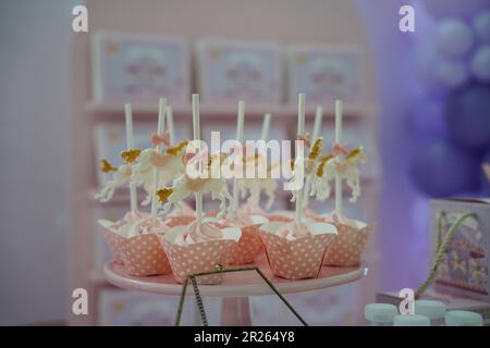 Süße, schicke Cupcakes. Karussell Gold und rosa Cupcakes. Karussell-Themen-Party-Süßigkeiten für Catering. Stockfoto