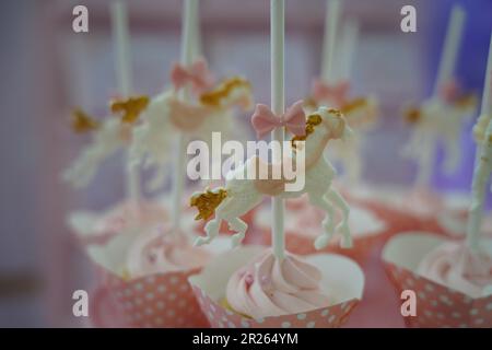 Süße, schicke Cupcakes. Karussell Gold und rosa Cupcakes. Karussell-Themen-Party-Süßigkeiten für Catering. Stockfoto