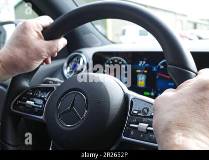 Itterbeck, Deutschland - April 23 2023 Hände eines Mannes, der das Lenkrad eines modernen Mercedes Benz hält. Es ist ein elektrischer EQA 250. Stockfoto