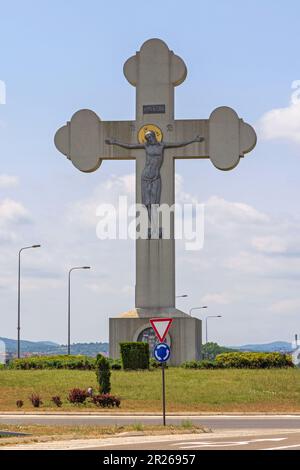 Kragujevac, Serbien - 26. Mai 2022: Großes Betonkreuz mit Jesus Christus Kreuzigung am Kreisverkehr am Eingang zur Stadt. Stockfoto