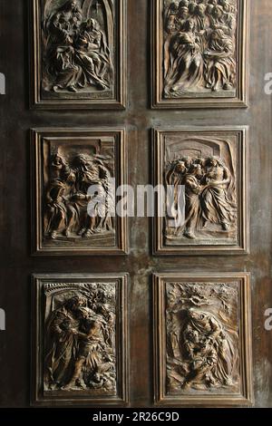 Gravina, Italien. Die wunderschöne Eingangstür in die römisch-katholische Kathedrale von Gravina, mit Basreliefs-Szenen aus dem Neuen Testament in Bronze. Stockfoto