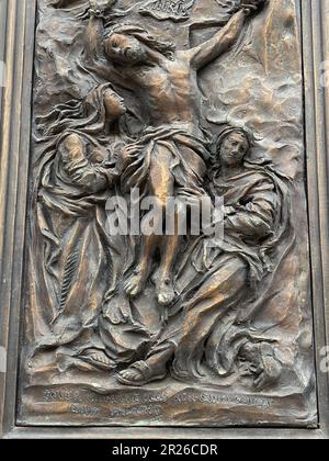 Gravina, Italien. Wunderschöne Details an der Eingangstür zur römisch-katholischen Kathedrale von Gravina. Darstellung der Kreuzigung Jesu. Stockfoto