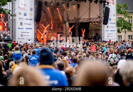 Oldenburg, Deutschland. 17. Mai 2023. Die Turnershow des Stedinger Turnverein Berne tritt während der Eröffnungszeremonie des Erlebnis Turnfest 2023 auf einer Bühne am Schlossplatz auf. Das Erlebnis Turnfest 2023 in Oldenburg hat mit einer Prozession und der Eröffnungszeremonie im Stadtzentrum begonnen. Bis zum 21. Mai 2023 findet die größte Sportveranstaltung in Norddeutschland mit rund 10.000 Teilnehmern statt. Kredit: Hauke-Christian Dittrich/dpa/Alamy Live News Stockfoto