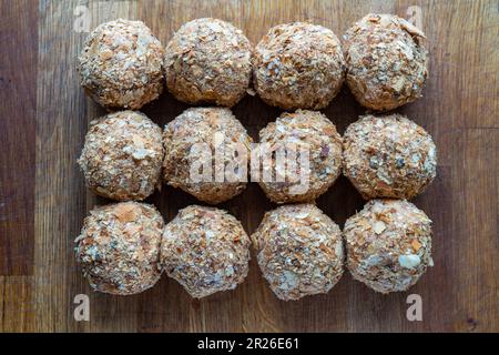 Rohe Scotch-Eier werden zu Hause hergestellt und auf einem charmanten rustikalen Holzbrett mit Blick von oben präsentiert. Die Anordnung bietet eine flache Sicht, al. Stockfoto