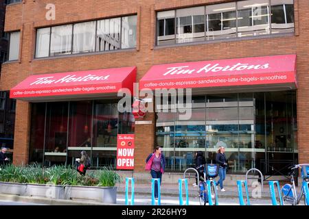 Tim Hortons Cafe Leute, die am Fahrradparkplatz vorbeifahren Big City Life Restaurant in der Innenstadt Snack Fast Food köstliches Vancouver Canada 2023 Stockfoto