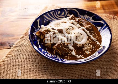 Enchiladas de Mole. Auch bekannt als Mole poblano enchiladas, sind sie ein typisches mexikanisches Gericht, das in Mexiko und dem Rest der Welt sehr beliebt ist. Stockfoto