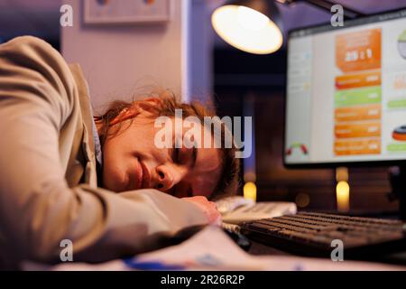 Überarbeiteter Manager, der auf dem Schreibtisch schläft Stockfoto