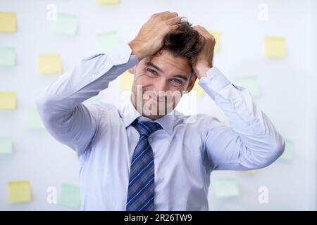Ich ziehe dir die Haare raus. Ein frustrierter junger Geschäftsmann im Büro. Stockfoto