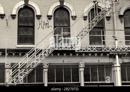 Naher Blick auf ein altes Lagerhaus in Cleveland, Ohio, mit Feuertreppe, in Sepiagarben Stockfoto