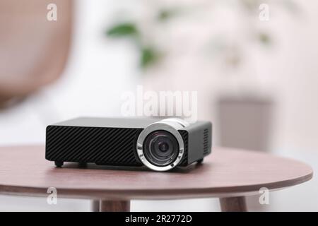 Moderner Videoprojektor auf Holztisch im Innenbereich Stockfoto