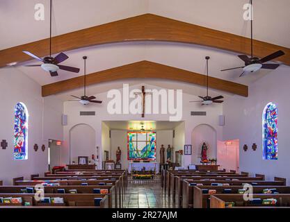 Borrego Springs, CA, USA - 24. April 2023: In der katholischen Kirche Saint Richards sind bunte Fenster, Statuen, kroen und Bänke mit Gebetsbüchern zu sehen. Stockfoto