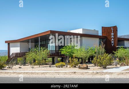 Borrego Springs, CA, USA - 24. April 2023: Öffentliche Bibliothek, modernes Gebäude, umgeben von Wüstenlandschaft unter blauem Himmel. Stockfoto