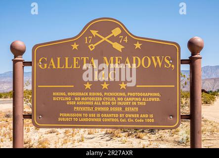 Borrego Springs, CA, USA - 24. April 2023: Galleta Meadows LLC-Schild, gelbe Buchstaben auf braunem Hintergrund, in Wüstenlandschaft entlang der Straße unter Blau Stockfoto