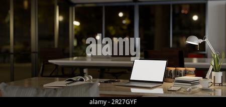 Arbeitsplatz bei Nacht mit Laptop-Computer-Modell mit weißem Bildschirm, Tischleuchte und Zubehör auf einem Tisch in einem modernen, dunklen Büroraum. 3D-Rendering, 3D-Illustration Stockfoto