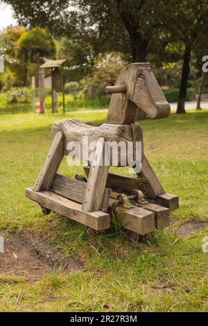 Rustikales Spielzeug in einem Park, Schaukelstuhl in Form eines hölzernen Pferdes, Hintergrund mit Natur, Dekorationsobjekt für Kinder, Details eines Handwerksobjekts Stockfoto