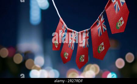 Eine Girlande mit Bermuda-Nationalflaggen auf abstraktem, verschwommenem Hintergrund. Stockfoto