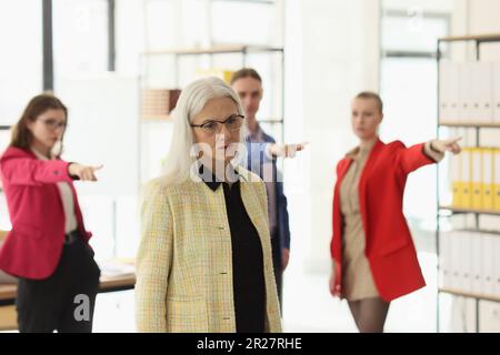Beleidigende Kollegen geben den älteren Mitarbeitern im Firmenbüro die Schuld Stockfoto