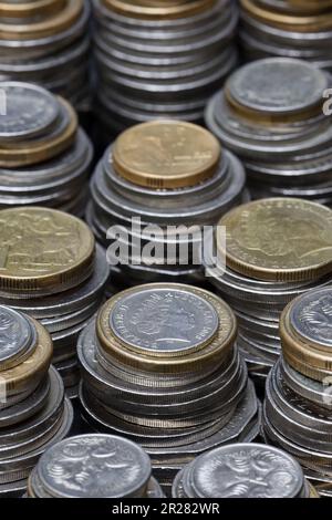 Ein Stapel gestapelter australischer Münzen für zwei und ein Dollar, fünfzig, zwanzig, zehn und fünf Cent füllt den Rahmen mit einem flachen Fokus bei sanfter Beleuchtung Stockfoto