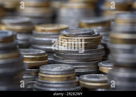 Ein Stapel gestapelter australischer Münzen für zwei und ein Dollar, fünfzig, zwanzig, zehn und fünf Cent füllt den Rahmen mit einem flachen Fokus bei sanfter Beleuchtung Stockfoto