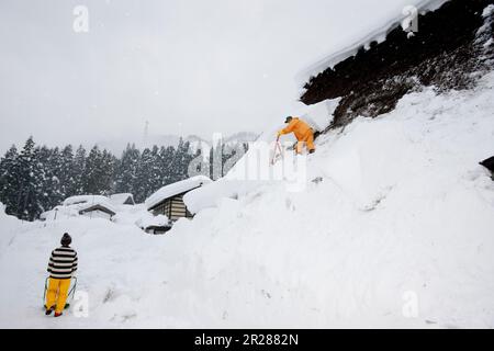 Schneeräumen vom Dach in Gokayama Gassho-zukuri Stockfoto