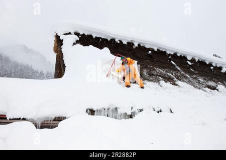 Schneeräumen vom Dach in Gokayama Gassho-zukuri Stockfoto