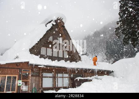 Schneeräumen vom Dach in Gokayama Gassho-zukuri Stockfoto