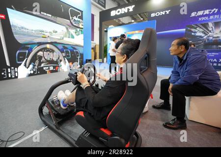 QINGDAO, CHINA - 17. MAI 2023 - Besucher erleben Fahrsimulationsgeräte auf der China International Consumer Electronics Expo 2023 in Qingdao, S. Stockfoto