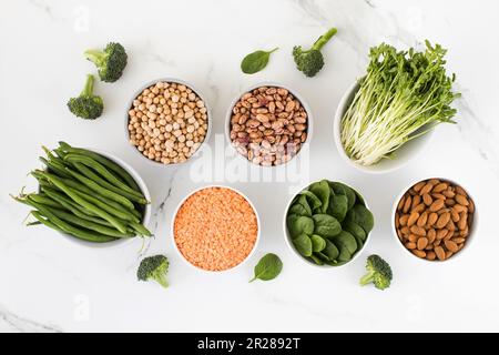 Hülsenfrüchte, Spinat auf hellem Hintergrund. Pflanzliches Eiweiß. Vegetarismus, gesunde Ernährung. Stockfoto