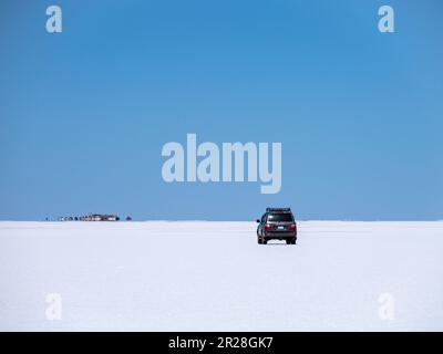 Fahrt mit dem Geländewagen auf Salar de Uyuni in Bolivien in Richtung Salt Hotel am Horizont Stockfoto