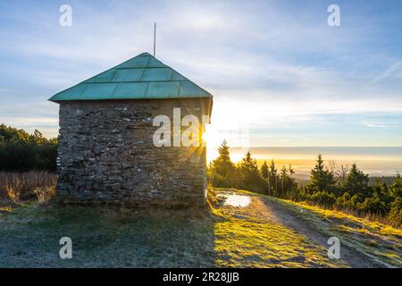 Ein frostiger, sonniger Morgen mit Sonnenstrahlen, die durch einen Steinunterschlupf im Jeleni studanka im Hruby-Jesenik-Gebirge in der Tschechischen Republik scheinen Stockfoto