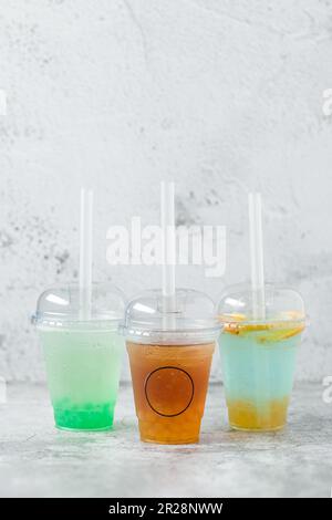 Fruchtiger Bubble Tea in einem Glasbecher auf grauem Hintergrund Stockfoto