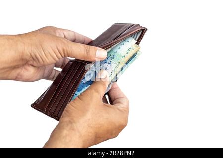 Ein paar Währungsscheine aus einer Brieftasche auf isoliertem weißem Hintergrund herausnehmen Stockfoto