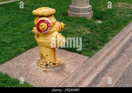 Alter gelber Feuerhydrant mit Schild für Außerbetriebsetzung Stockfoto