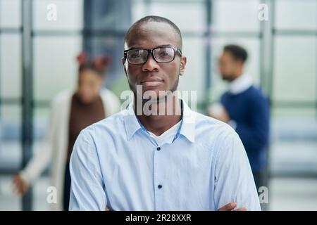 Glücklicher afroamerikanischer junger Geschäftsmann im formellen Anzug mit Brillenporträt. Stockfoto