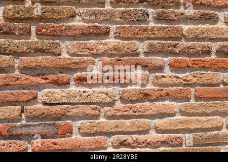 Nahaufnahme einer alten Backsteinmauer an sonnigen Tagen. Stockfoto