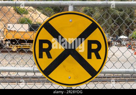 Schild für Bahnübergang am Metallzaun Stockfoto