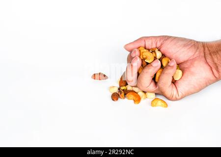 Konzept, Trail-Mix-Tag. Handvoll Männer auf weißem Hintergrund. Nahaufnahme. Kopieren Sie den linken Bereich für Design oder Text. Stockfoto