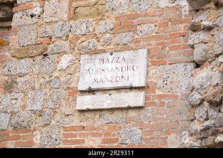 Siena, Italien - 7. April 2022: Traditionelles Marmorstraßenschild in der historischen Stadt Siena, Toskana, Italien. Piazza Alessandro Manzoni Stockfoto