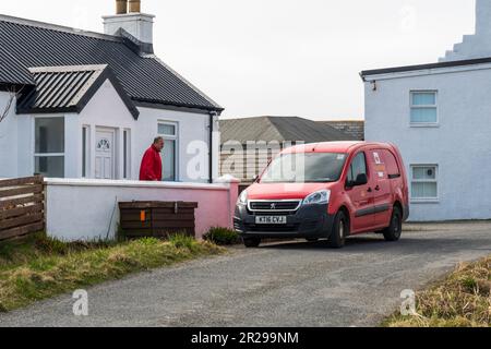 Postbote, die Häuser in Burravoe beliefern, am südlichen Ende von Yell, Shetland. Stockfoto