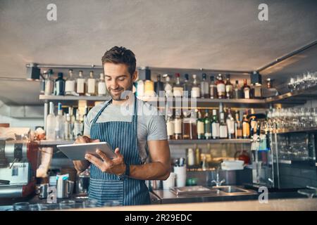 Mann im Restaurant, Tablet und Kleinunternehmen mit Bestandskontrolle, Unternehmer im Gastgewerbe und Konnektivität. Männlicher Besitzer, Schriftrolle und Café Stockfoto
