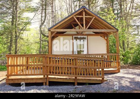 Moderne Holzjurte, eingebettet in den Wald. Rollstuhlgerecht. Stockfoto