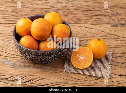 Cravo oder RosenZitronen in einer Schüssel über einem Holztisch. Stockfoto